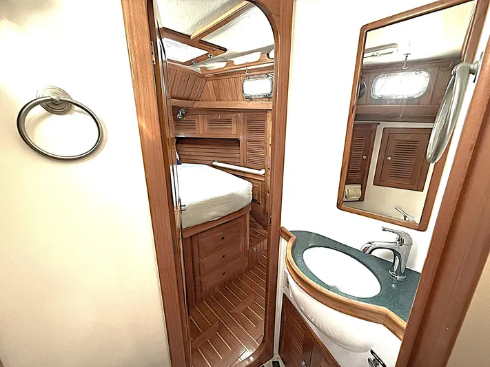 Sarah Yacht Photos Pics Interior of 2000 Cabo Rico Pearl Edition yacht, featuring wooden cabinetry and compact bathroom.