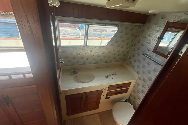  Yacht Photos Pics 1981 Tollycraft 48 Motor Yacht bathroom with sink, toilet, and window view.