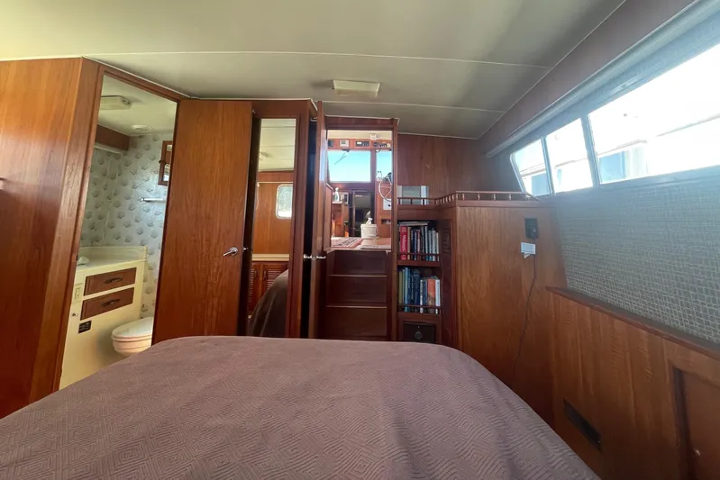  Yacht Photos Pics 1981 Tollycraft 48 Motor Yacht interior cabin with wood paneling and built-in bookshelves.