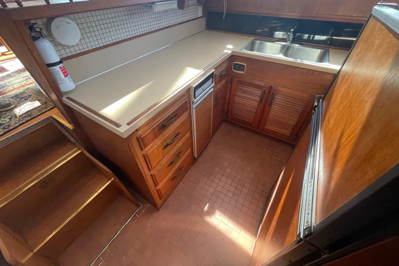  Yacht Photos Pics 1981 Tollycraft 48 Motor Yacht kitchen with wooden cabinets and dual sinks.