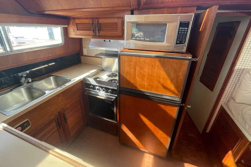  Yacht Photos Pics 1981 Tollycraft 48 Motor Yacht kitchen with stove, microwave, fridge, and double sink.