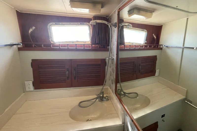  Yacht Photos Pics 1981 Tollycraft 48 Motor Yacht bathroom with dual sinks and mirrored cabinet.