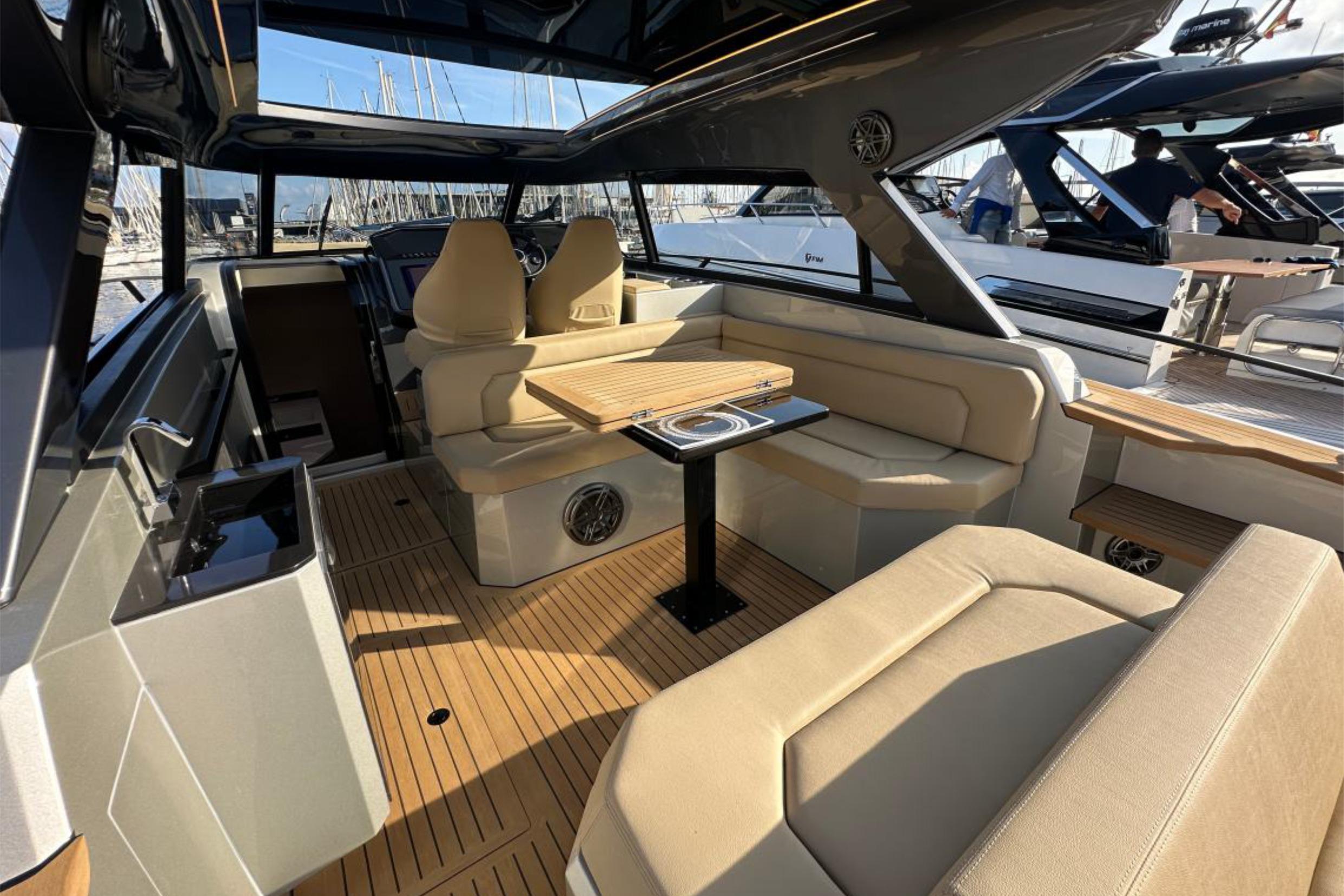 Luxurious interior of 2025 Focus 3X yacht with beige seating and wooden accents.