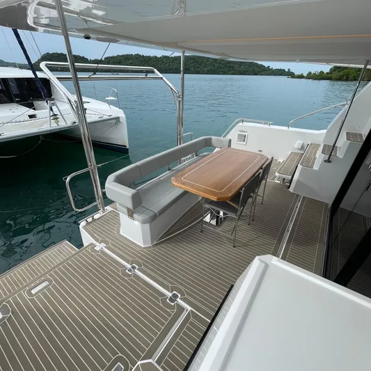 Leopard 40pc Yacht Photos Pics 2025 Leopard 40PC yacht deck with seating and table, overlooking serene waters.