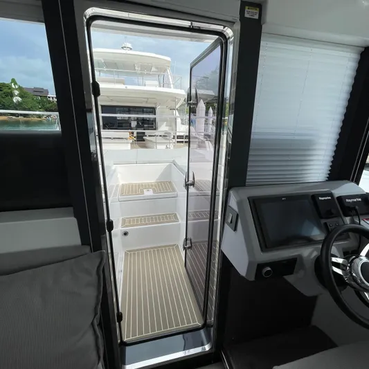 Leopard 40pc Yacht Photos Pics Interior view of 2025 Leopard 40PC yacht, featuring helm and open door to deck.
