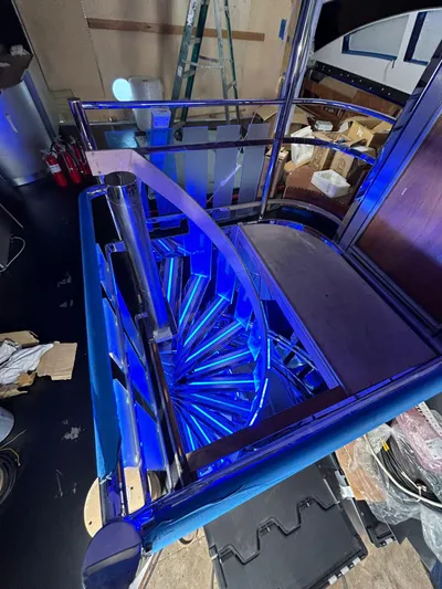 1992/2016 Heesen Motor Yacht Yacht Photos Pics Illuminated spiral staircase on 1992 Heesen 141 Motor Yacht, featuring modern blue lighting.