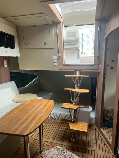 Saviour Yacht Photos Pics Interior of 2022 Evolve 400HT yacht with wooden table, modern staircase, and cozy seating area.