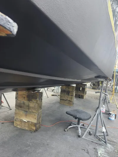 Saviour Yacht Photos Pics 2022 Evolve 400HT boat hull on blocks in a maintenance area.