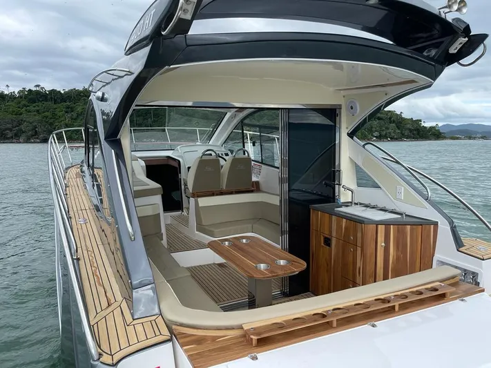 Saviour Yacht Photos Pics 2022 Evolve 400HT yacht interior with seating, table, and kitchenette on the water.