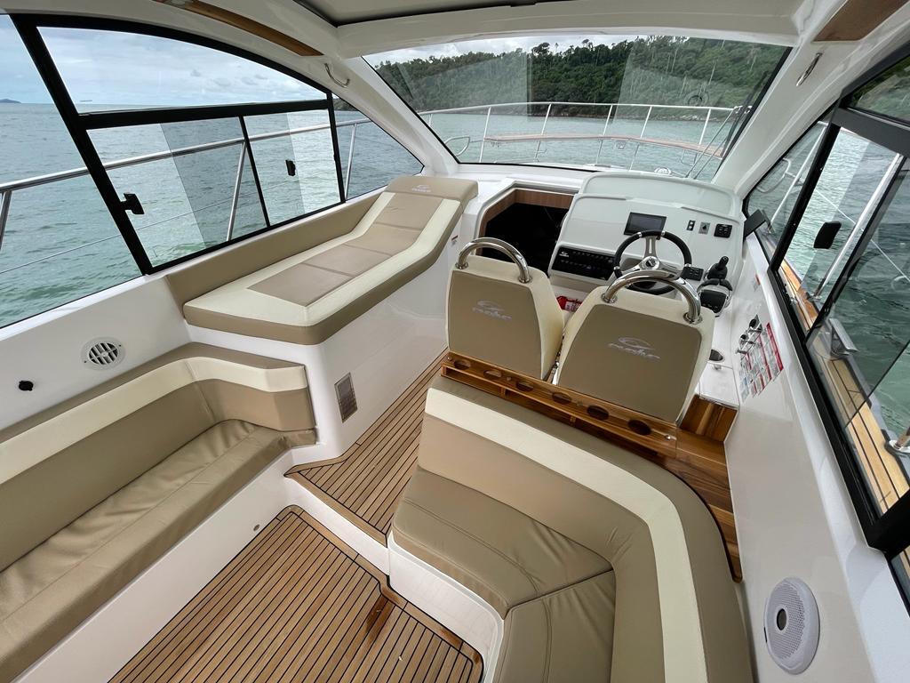 Interior of 2022 Evolve 400HT yacht with beige seating and modern helm.