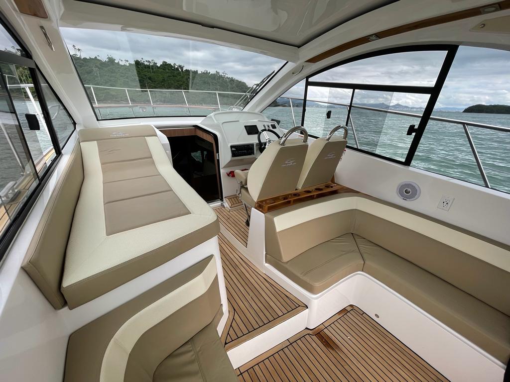 Luxurious interior of 2022 Evolve 400HT yacht with beige seating and wood flooring.