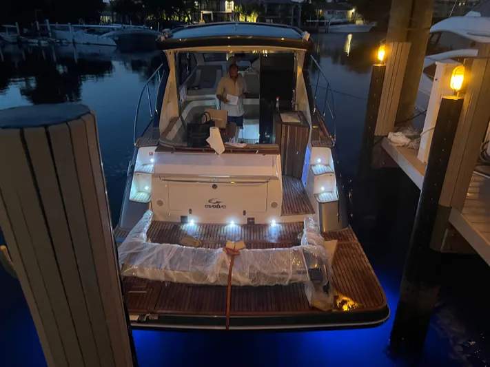 Saviour Yacht Photos Pics Evolve 400HT 2022 yacht docked at night with illuminated deck and person onboard.