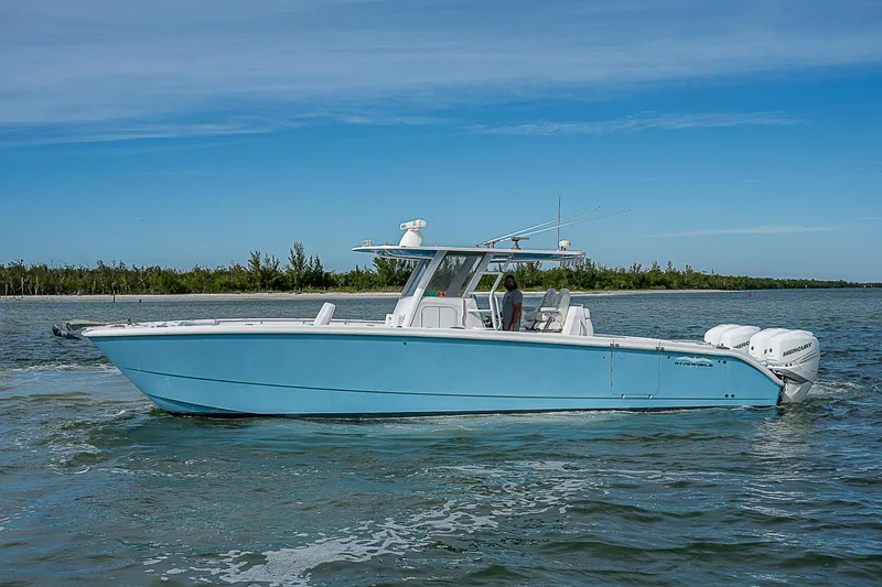 Yacht Photos Pics 2020 Invincible 37 Catamaran on water, blue hull, twin Mercury engines, clear sky.