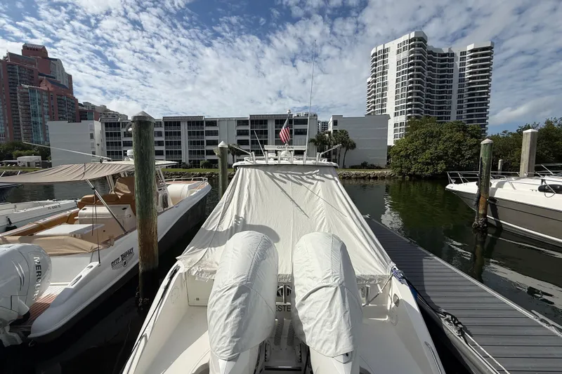 Alroma Yacht Photos Pics 2022 Pursuit S 358 Sport boat docked in a marina with cityscape background.