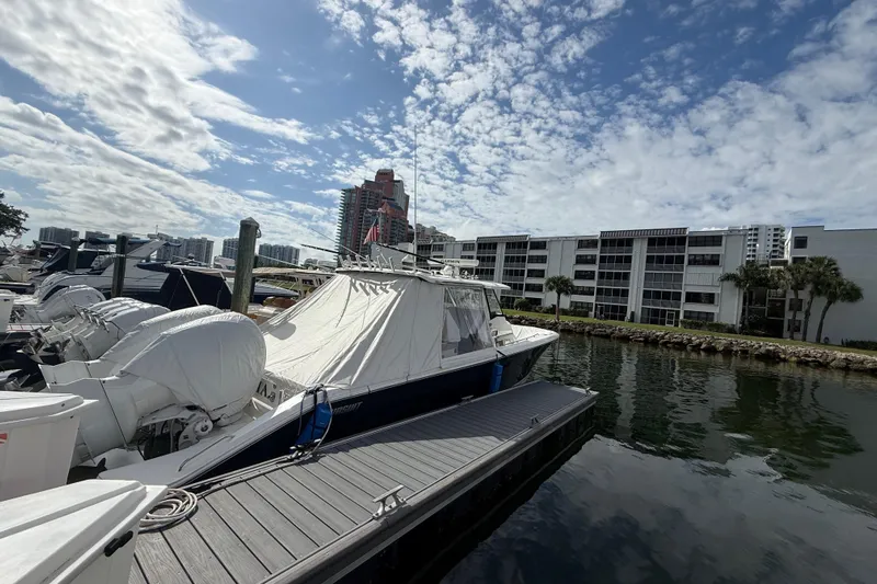 Alroma Yacht Photos Pics 2022 Pursuit S 358 Sport boat docked at marina, under a partly cloudy sky.