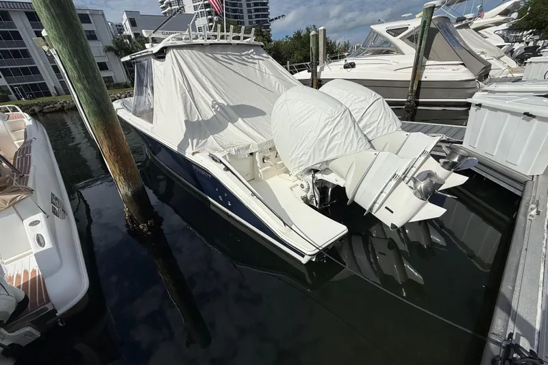 Alroma Yacht Photos Pics 2022 Pursuit S 358 Sport boat docked, covered, with twin outboard engines.