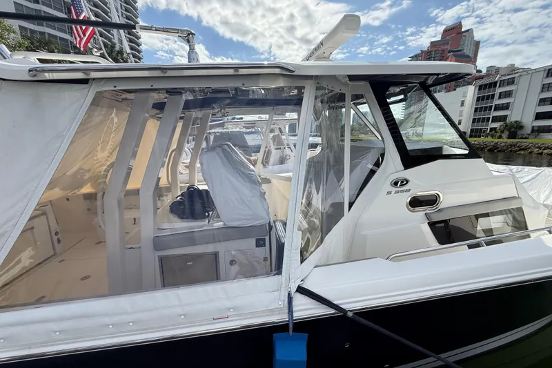 Alroma Yacht Photos Pics 2022 Pursuit S 358 Sport boat docked, featuring sleek design and enclosed cabin.
