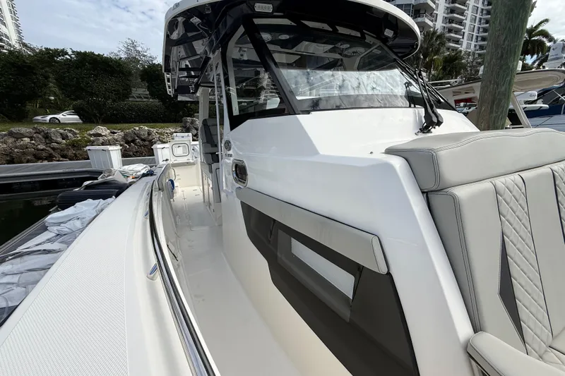 Alroma Yacht Photos Pics 2022 Pursuit S 358 Sport boat docked, showcasing sleek design and luxurious seating.
