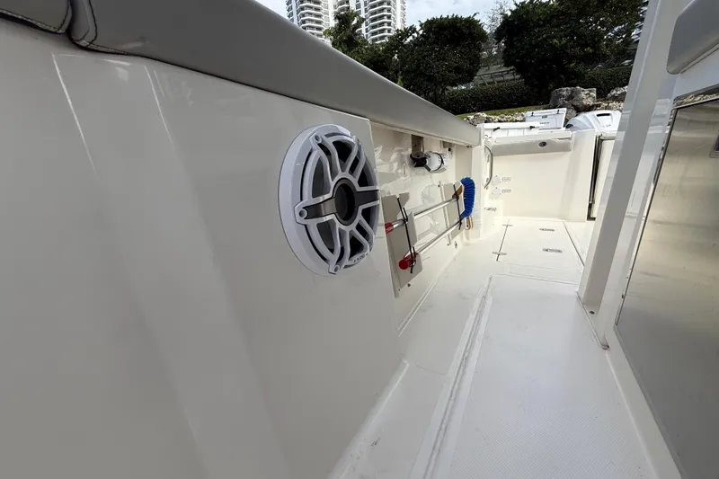 Alroma Yacht Photos Pics 2022 Pursuit S 358 Sport boat interior with speaker and cleaning tools.