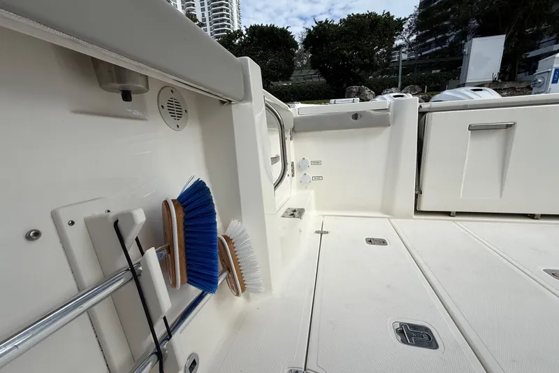 Alroma Yacht Photos Pics 2022 Pursuit S 358 Sport boat deck with cleaning brushes and storage compartments.