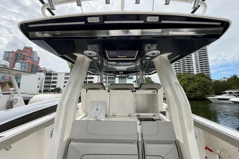 Alroma Yacht Photos Pics 2022 Pursuit S 358 Sport boat interior with modern seating and storage, docked near buildings.