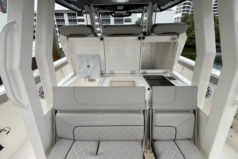 Alroma Yacht Photos Pics 2022 Pursuit S 358 Sport boat interior with seating and kitchenette area.
