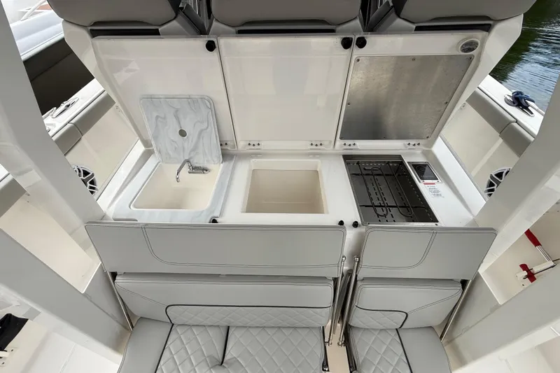 Alroma Yacht Photos Pics 2022 Pursuit S 358 Sport boat galley with sink, grill, and storage compartments.