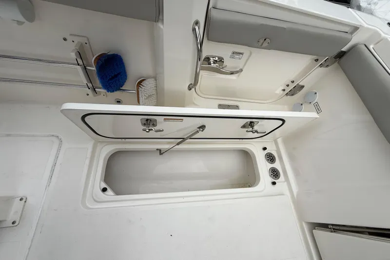 Alroma Yacht Photos Pics 2022 Pursuit S 358 Sport boat storage compartment with cleaning brushes.