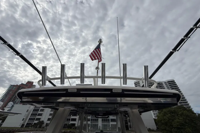 Alroma Yacht Photos Pics 2022 Pursuit S 358 Sport boat with American flag against cloudy sky backdrop.