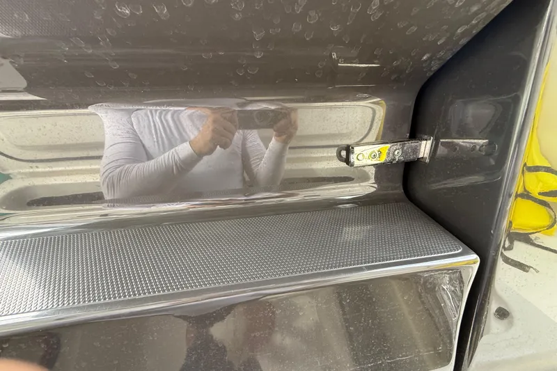 Alroma Yacht Photos Pics 2022 Pursuit S 358 Sport boat interior detail with reflective surface and latch mechanism.