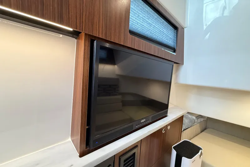 Alroma Yacht Photos Pics 2022 Pursuit S 358 Sport interior with TV and modern wood paneling.