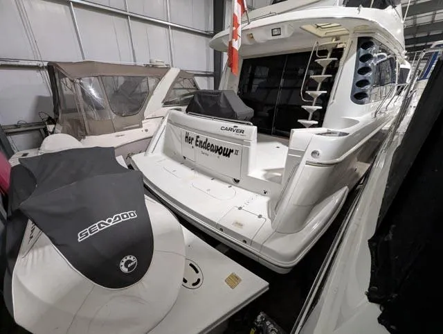 Her Endeavour II Yacht Photos Pics 1999 Carver 530 Voyager Pilothouse yacht in storage with Sea-Doo jet ski nearby.