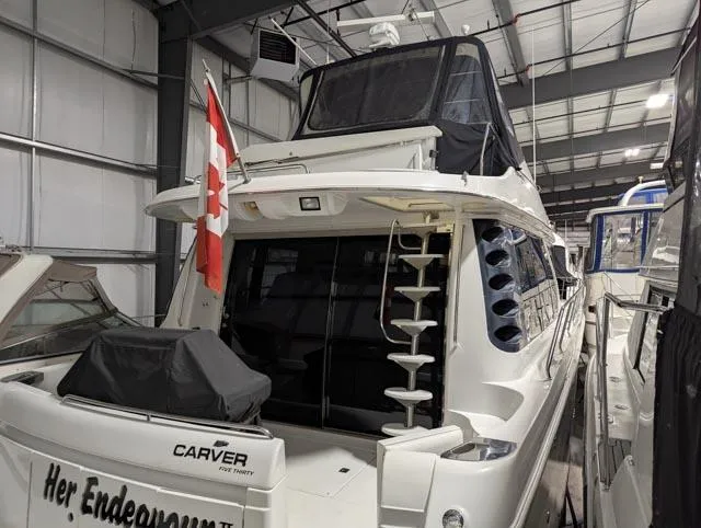 Her Endeavour II Yacht Photos Pics 1999 Carver 530 Voyager Pilothouse yacht in indoor storage, featuring a Canadian flag.