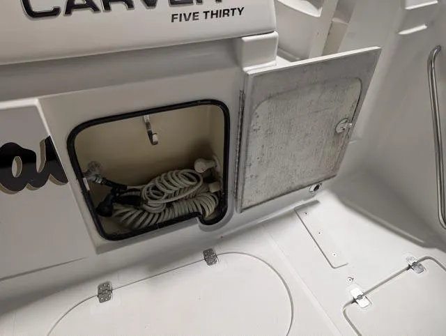 Her Endeavour II Yacht Photos Pics 1999 Carver 530 Voyager Pilothouse storage compartment with coiled hose and open hatch.