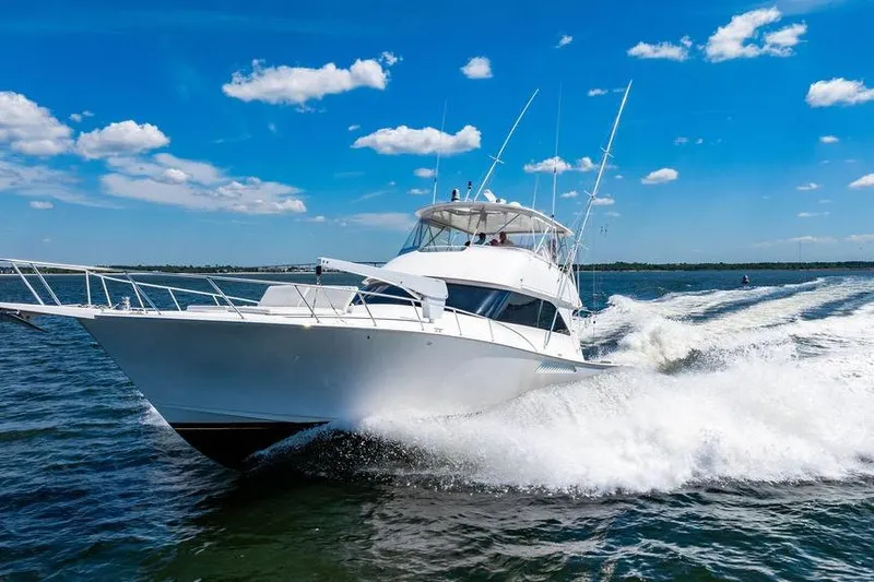 Reel Southern Yacht Photos Pics 2006 Viking 56 Convertible yacht cruising on open water under a clear blue sky.