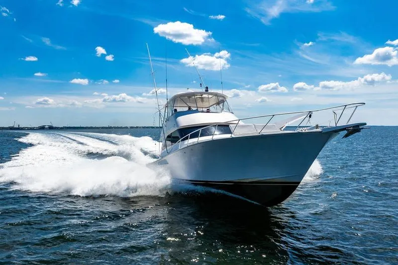 Reel Southern Yacht Photos Pics 2006 Viking 56 Convertible yacht cruising on open water under a clear blue sky.