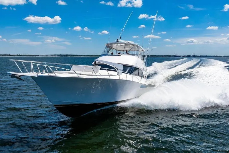 Reel Southern Yacht Photos Pics 2006 Viking 56 Convertible yacht cruising on open water under a clear blue sky.