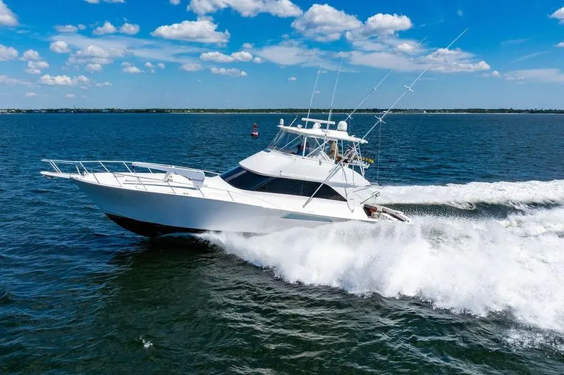 Reel Southern Yacht Photos Pics 2006 Viking 56 Convertible yacht cruising on open water under a clear blue sky.