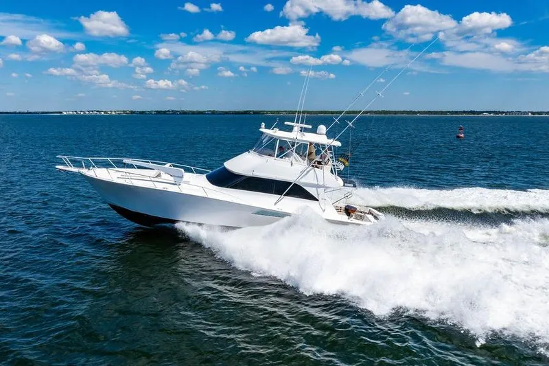 Reel Southern Yacht Photos Pics 2006 Viking 56 Convertible yacht cruising on open water under a clear blue sky.