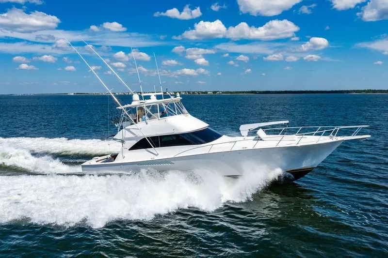 Reel Southern Yacht Photos Pics 2006 Viking 56 Convertible yacht cruising on open water under a clear blue sky.