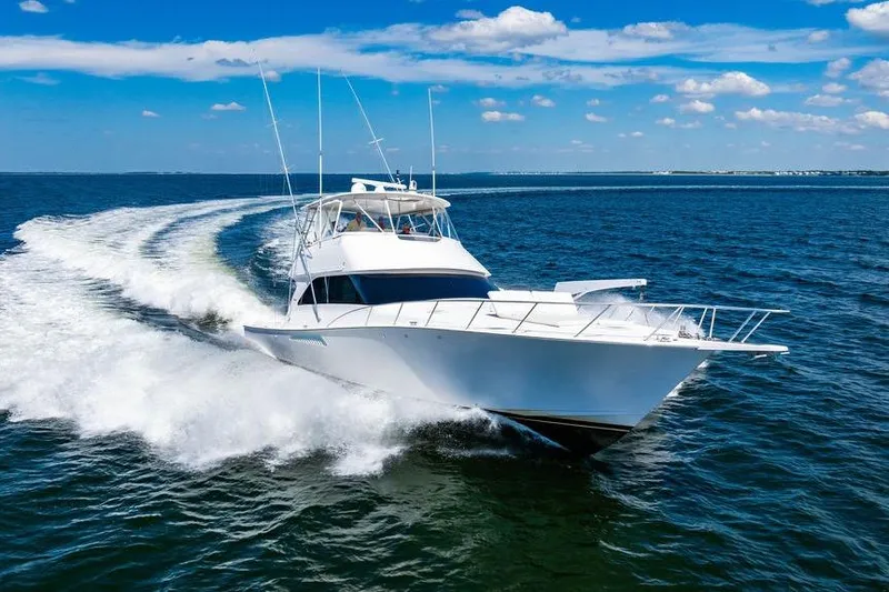 Reel Southern Yacht Photos Pics 2006 Viking 56 Convertible yacht cruising on open water under a clear blue sky.