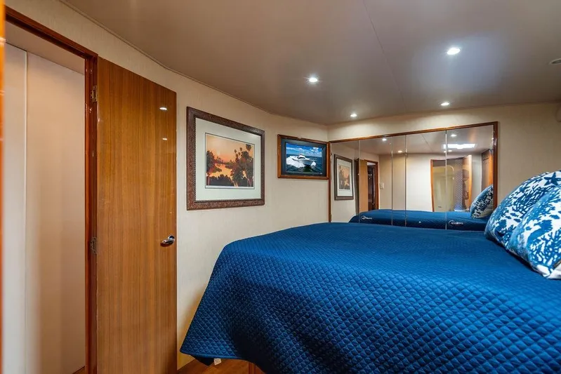 Reel Southern Yacht Photos Pics Luxurious bedroom interior of 2006 Viking 56 Convertible yacht with blue bedding and artwork.