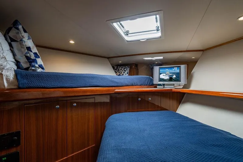 Reel Southern Yacht Photos Pics Cozy cabin interior of 2006 Viking 56 Convertible yacht with blue bedding and TV.