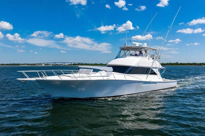 Reel Southern Yacht Photos Pics 2006 Viking 56 Convertible yacht cruising on open water under a clear blue sky.