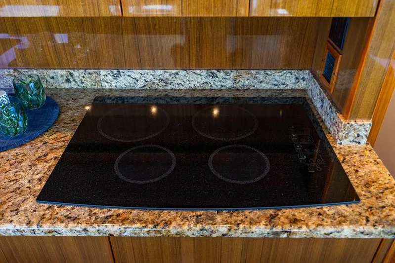 Reel Southern Yacht Photos Pics Granite countertop with electric cooktop in 2006 Viking 56 Convertible yacht kitchen.