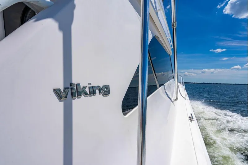 Reel Southern Yacht Photos Pics 2006 Viking 56 Convertible yacht cruising on open water under clear blue sky.