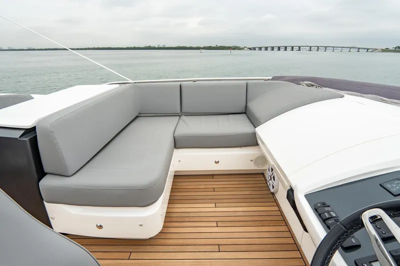 Cinderella Yacht Photos Pics 2017 Princess S65 yacht with gray seating and wooden deck, overlooking calm waters.