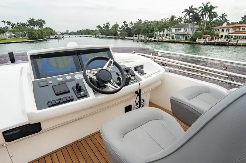 Cinderella Yacht Photos Pics 2017 Princess S65 yacht helm with modern controls, overlooking a scenic waterfront.