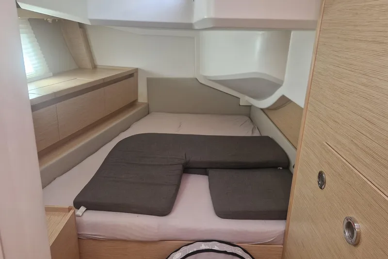  Yacht Photos Pics Cozy cabin interior of 2019 Hanse 588 yacht with modern wood finish and cushioned bed.