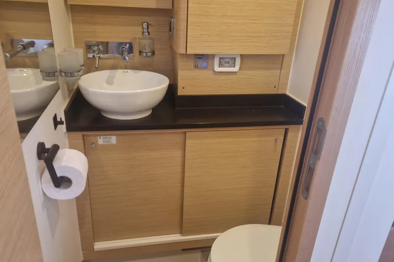  Yacht Photos Pics Modern bathroom interior on 2019 Hanse 588 yacht, featuring sleek wooden cabinetry and vessel sink.